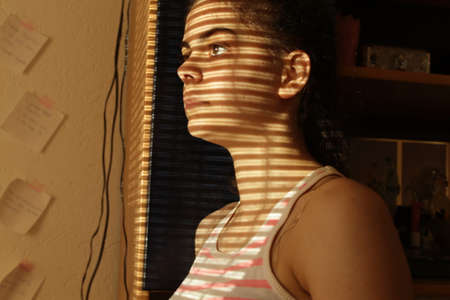 Close-up of a young girl's face looking out the windowの写真素材