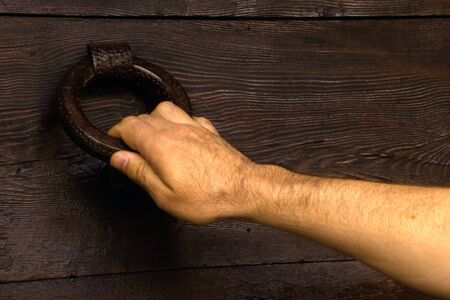 man's hand holding a door's knockerの写真素材