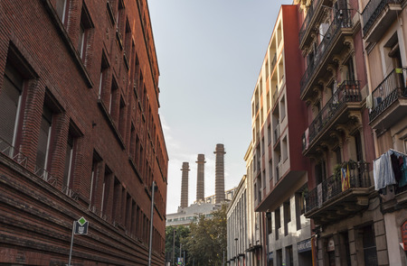 BARCELONA-SPAIN,SEPTEMBER 29,2014: Street in Raval quarter with three chimney at background. Barcelona.のeditorial素材