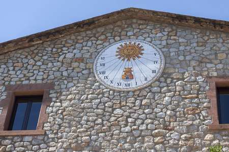 CASTELLDEFELS,SPAIN-JULY 17,2016: Sundial over stone wall, rural house, Castelldefels, province Barcelona,Catalonia.のeditorial素材