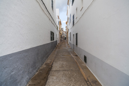 CIUTADELLA,SPAIN- JANUARY 22,2017: Narrow street and colored buildings,historic area,Menorca island,Balearic Islands.のeditorial素材