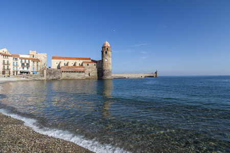 COLLIOURE,FRANCE-NOVEMBER 30,2011: Mediterranean beach and tower church ancient building in french village of Collioure, Cote Vermeille, Occitanie, France.のeditorial素材