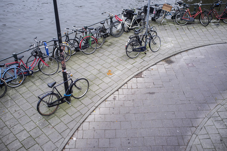 AMSTERDAM-NOVEMBER 11,2011:Parked bicycles by the canal in Amsterdam.のeditorial素材
