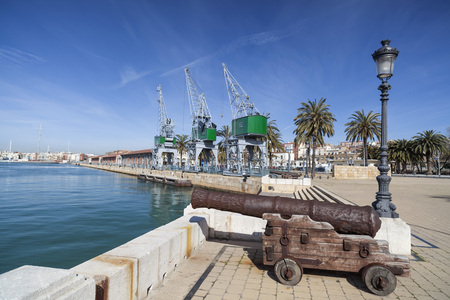 TARRAGONA,SPAIN-MARCH 21,2013: Port view, old canon and cranes, Tarragona,Catalonia.のeditorial素材