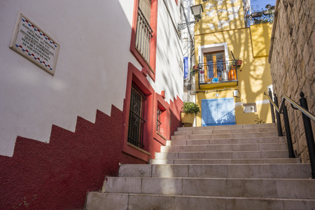 ALICANTE, SPAIN- JANUARY 18, 2018: Colored picturesque houses, street.Typical neighborhood historic center, casco antiguo,barrio santa cruz.Alicante, Spain.のeditorial素材