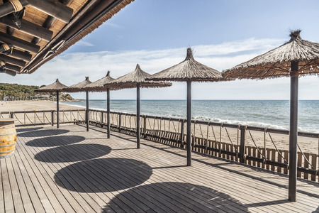 Mediterranean sea, spring sunny day, baech and umbrella terrace bar, Costa Dorada, Catalonia, Spain.の写真素材
