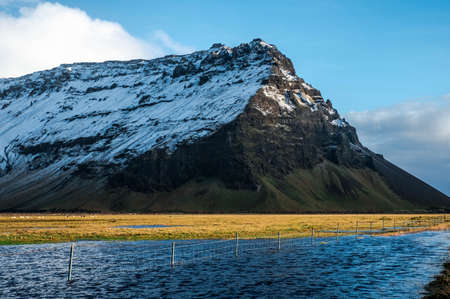 A snowy mountain with a lake in South Iceland
