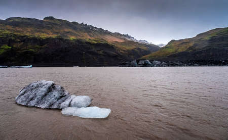 An ice floe in the pink lagoon where the Solheimajokull glacier ends, South Iceland, near Vik