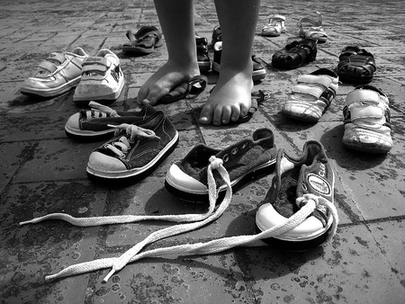 Little child feet surrounded by small shoes, on a Roof House の写真素材
