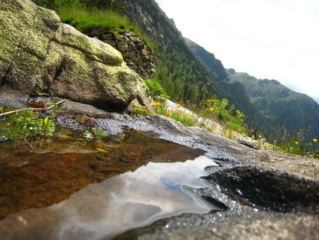 Puddle reflecting sky and mountains in a valley of Pyrenees の写真素材