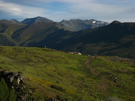 A meadow and high mountains under blue and white sky の写真素材