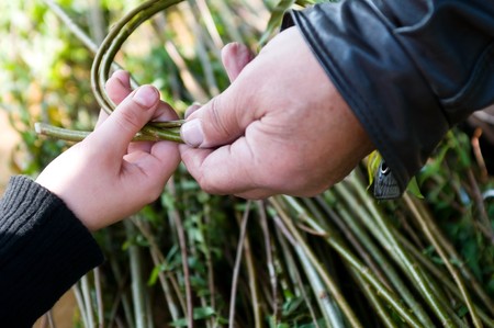 Man teaching child making a wicker basket 