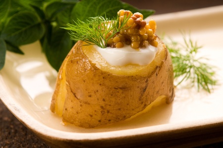 Baked potato with sour cream, grain Dijon mustard and herbsの写真素材