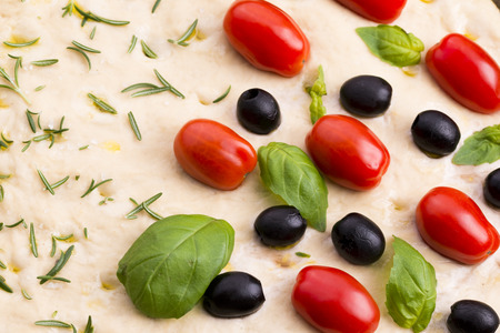 Focaccia with black olives, tomatoes and basilの写真素材