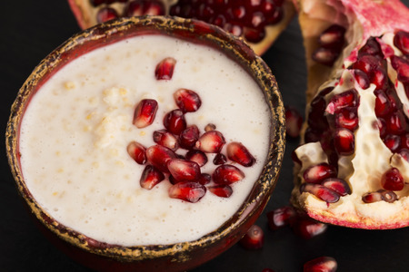 Dish of banana millet breakfast pudding with pomegranateの写真素材