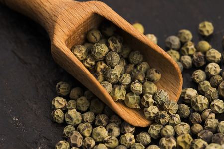 Green Peppercorns on wooden background