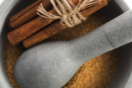 Cinnamon sticks with pure cane brown sugar in mortarの写真素材