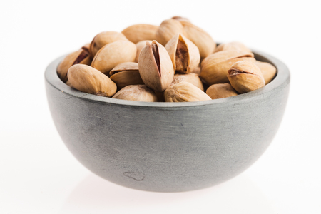bowl of pistachios on white backgroundの写真素材