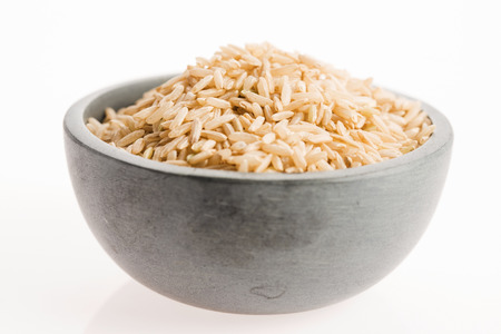 brown rice in a bowl isolated on white backgroundの写真素材