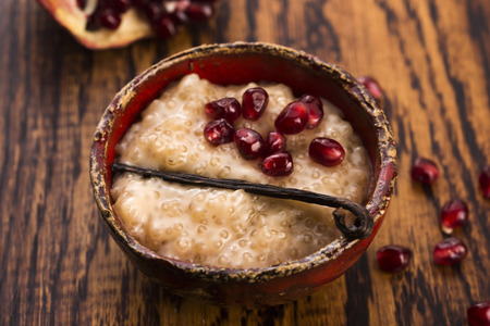 A bowl of tapioca pudding with vanilla and pomegranateの写真素材