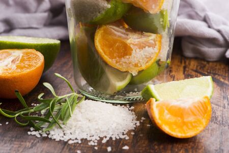 Preserved Lime and Mandarin with salt on a wooden boardの写真素材