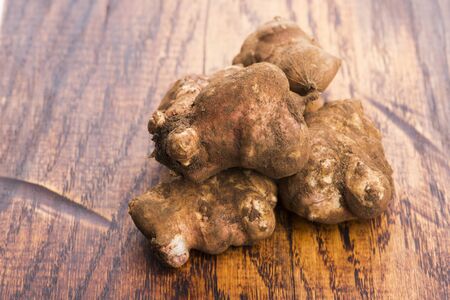Raw Whole ans sliced Jerusalem artichokes on a cutting board