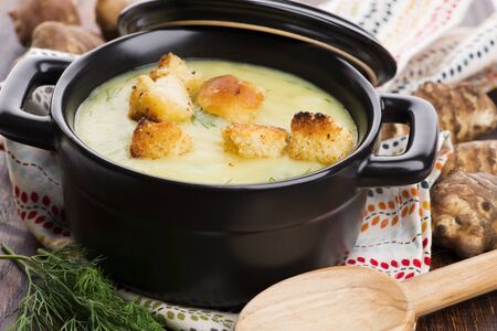 Creamy Jerusalem artichoke soup on wooden backgroundの写真素材