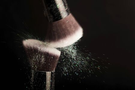 Cosmetics brush and colorful makeup powderの写真素材