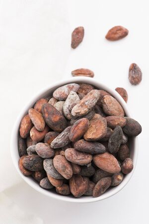 Bowl of cacao beans on a whiteの写真素材