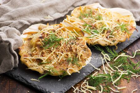 Baked scallops with cheese and spicy sauce. Delicate is a real pleasure.