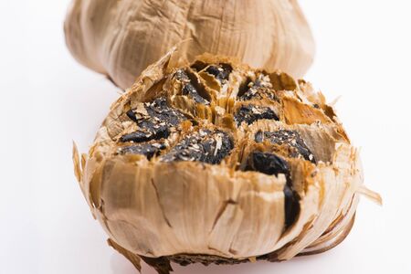 Black garlic cloves isolated on white backgroundの写真素材