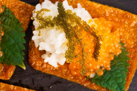 Inari sushi with caviar, rice, shiso and umibudoの写真素材