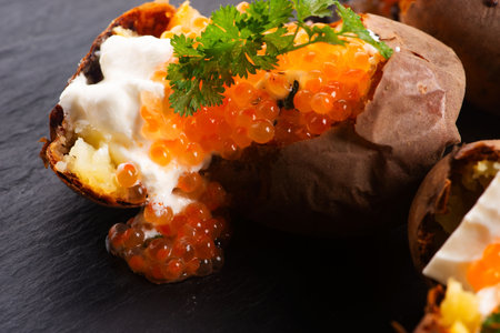 Baked potatoes with cream cheese and red caviarの写真素材