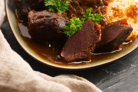 Stewed goose stomach.  Traditional Polish meat on a dark background.の写真素材
