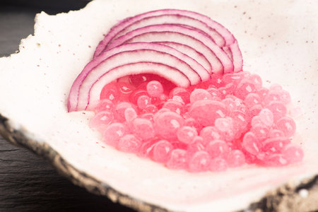 Molecular onion caviar balls on ceramics plateの写真素材