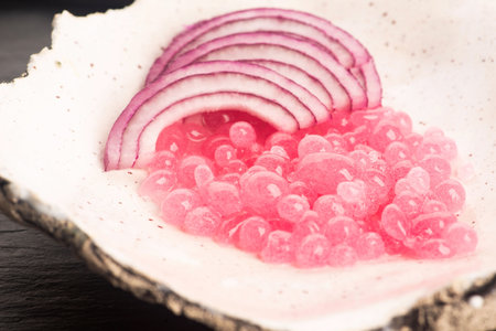 Molecular onion caviar balls on ceramics plateの写真素材
