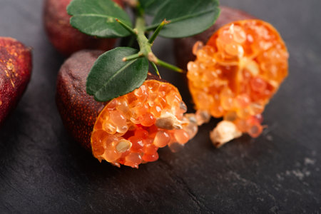 Finger Lime Cut Open with Citrus Caviar on Black Stone Baseの写真素材