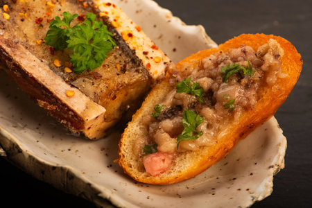 Roasted Bone Marrow with Spices and Baguette in Handmade Ceramic Bowlの写真素材