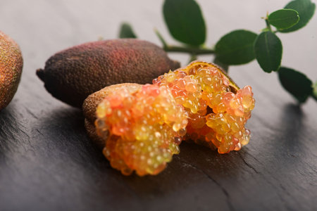 Finger Lime Cut Open with Citrus Caviar on Black Stone Baseの写真素材