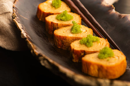 Japanese Tamagoyaki with Green Wasabi Caviar on Ceramic Standの写真素材