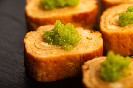 Japanese Tamagoyaki with Green Wasabi Caviar on Black Stone Board