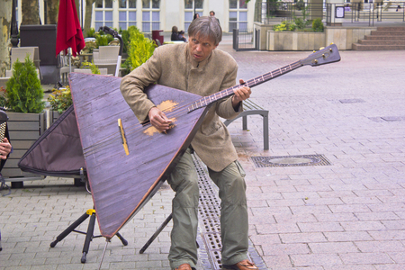 Ville de Luxembourg, Luxembourg - May, 15 2011 A man playing a balalaika in a Luxembourg square. Balalaika is a russian musical instrument, similar like a guitar.のeditorial素材