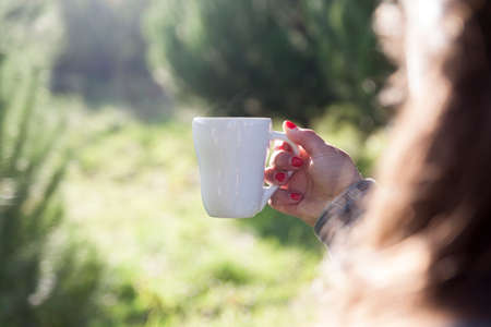 Woman holding a hot coffee mugの写真素材
