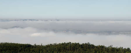 Above the sea of clouds on a mountain in Valongo, Portugal, overlooking Porto Metropolitan Areaの写真素材