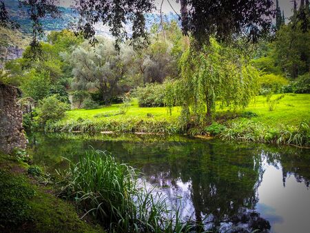 Ruins and refection in Giardini di Ninfa in Italyの写真素材