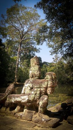 Curious and amazing guards statues in the brigde in Angkor Wat in Cambodia. Sunny day in summerの写真素材
