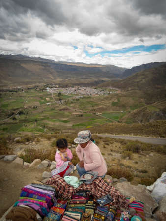Woman and his child selling souvenir in the Colca Canyon in Peru