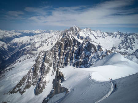 Line of skiers in the Vallee Blanche, Chamonix, France. Very touristic place and sunny day, no cloudsの写真素材