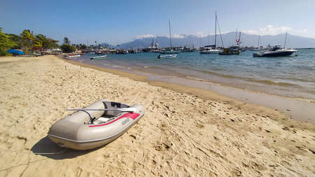 Isolated inflatable boat at the beach in Ilha Bela, Sao Paulo, Brazil. Amazing island in summerの写真素材