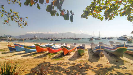 Beautiful traditional canoe at Ilha Bela, Sao Paulo, Brazil. Amazing beach, landscape and boats with different colorsの写真素材